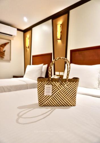 a rattan purse sitting on a bed in a hotel room at Red Coconut Beach Hotel Boracay in Boracay