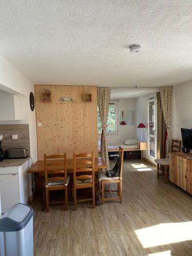 une cuisine et une salle à manger avec une table et des chaises dans l'établissement Pra-Loup 1500 Appartement spacieux et lumineux, à Uvernet