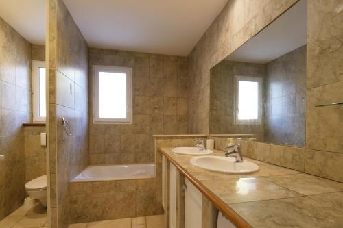 une salle de bain avec deux lavabos et une baignoire et des toilettes dans l'établissement Villa Mathea by Villa Plus, à Néoules