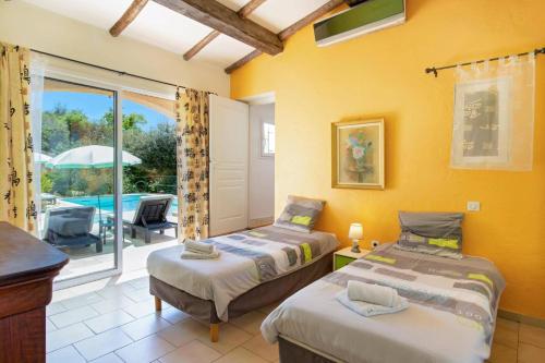 two beds in a room with a view of a pool at Villa Cabris by Villa Plus in Cabris