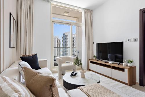 a living room with a couch and a tv at Silkhaus Vacation Homes Chic 1BDR near Canal at Al Reem Island in Abu Dhabi
