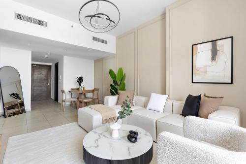 a living room with a white couch and a table at Silkhaus Vacation Homes Chic 1BDR near Canal at Al Reem Island in Abu Dhabi