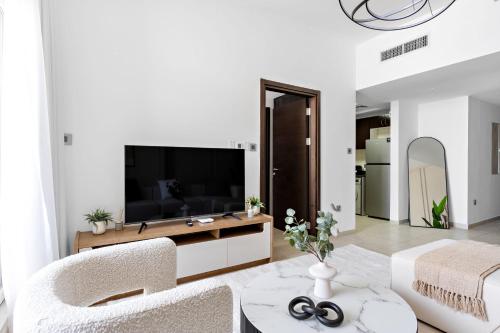 a living room with a television and a couch at Silkhaus Vacation Homes Chic 1BDR near Canal at Al Reem Island in Abu Dhabi