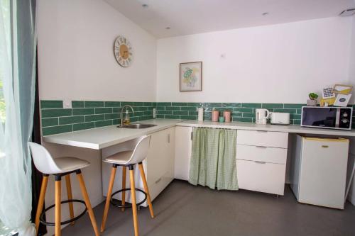 a kitchen with a sink and two bar stools at Villa Pezenas by Villa Plus in Pézenas