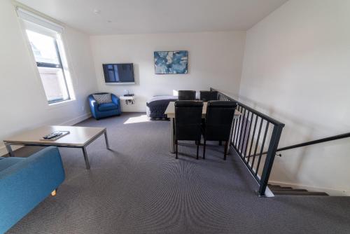 a living room with a couch and a table at 315 Euro Motel and Serviced Apartments in Dunedin