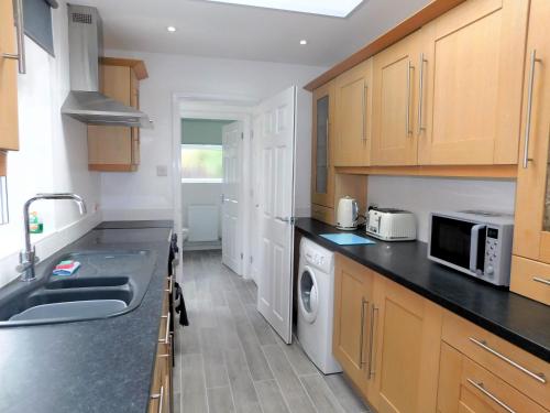 a kitchen with wooden cabinets and a sink at Philips Cottage in Sheringham