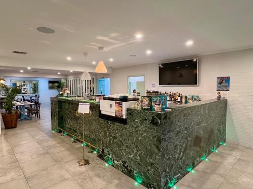 a lobby with a bar with green lights at Best Western Adelaide Airport in Adelaide