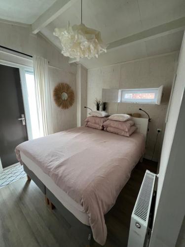 a bedroom with a large bed and a window at Studio Bluuven in Scharendijke