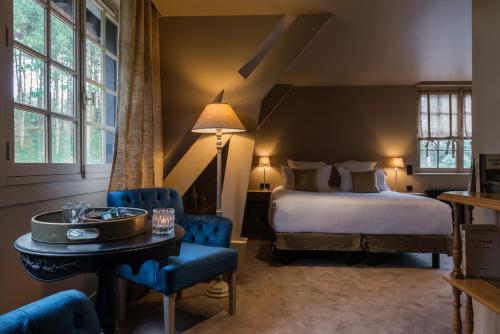 a bedroom with a bed and a table and chairs at Les Pins de César - La campagne d'Etretat in Saint-Jouin-Bruneval