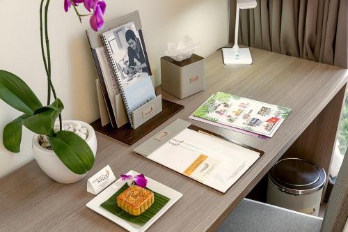 a desk with a plate of food and a plant on it at The Nalod Da Nang in Da Nang