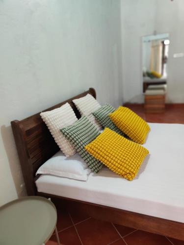 a bed with four pillows on top of it at The Sattva Nature Retreat in Avathi