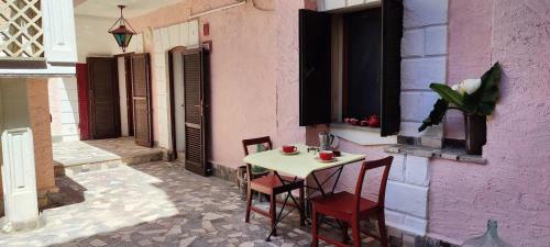 a table and chairs on a patio in a building at Appartement Anatra in Sorso