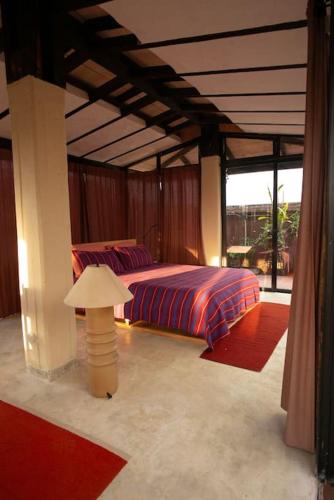a bedroom with a bed and a lamp in it at Rooftop Glass House in Old Town in Oaxaca City