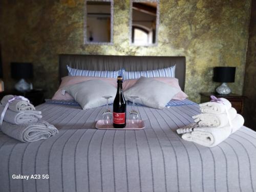 a bed with a bottle of wine and towels at Luxury b&b Le Rocce in Villasmundo