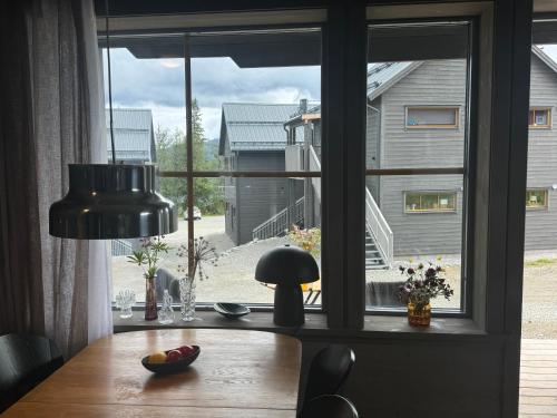 a table in front of a window with a view of a house at Funäsdalshöjden Funäsdalen in Funäsdalen
