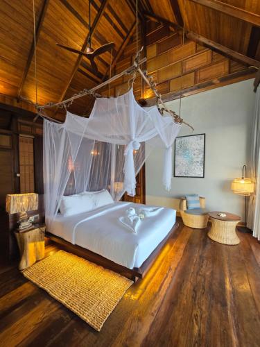a bedroom with a bed with a mosquito net at Full Moon Island Resort in Kaoh Sdach