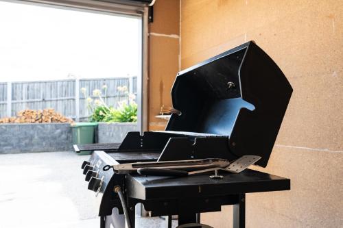 a black piano sitting next to a wall at Luxurious Hobart Holiday Home with Stunning Bay Views - Affordable, Family-Friendly, and Stylish in Sorell