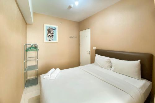 a bedroom with a large bed with white pillows at Comfort and Elegant 4BR Combined at Springlake Summarecon Bekasi Apartment By Travelio in Bekasi