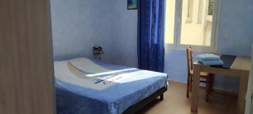 a bedroom with a bed and a desk and a window at Les hirondelles de L'Embisque in Bollène