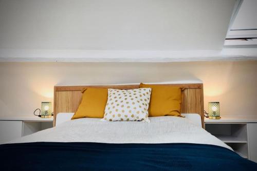 une chambre avec un lit avec des oreillers jaunes dans l'établissement Charmante maisonnette à 2 pas de la mer !, à Étretat