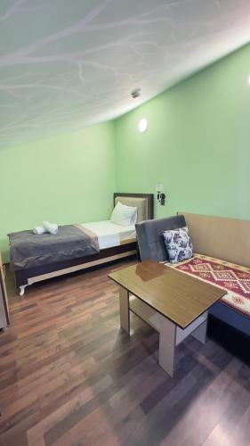 a room with two beds and a coffee table at Yaffle Inn Shaki Boutique Hotel in Sheki