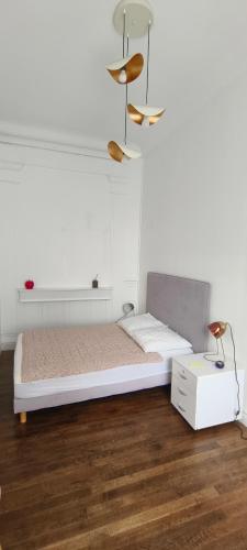 une chambre blanche avec un lit et une table dans l'établissement Mer 50 m à pied et Centre ville, à Villers-sur-Mer