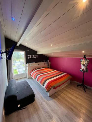 une chambre avec un lit et un mur rose dans l'établissement Maison PAU - BIZANOS, à Bizanos