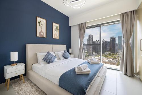 a bedroom with a large bed and a large window at 5 Minute Walk to The Fountains! Full Burj Khalifa View! 5-star Pool & Gym! in Dubai