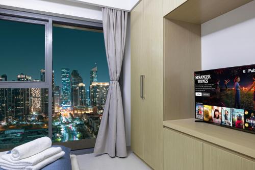 a room with a window with a view of a city at 5 Minute Walk to The Fountains! Full Burj Khalifa View! 5-star Pool & Gym! in Dubai