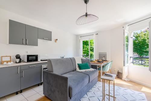 une cuisine et un salon avec un canapé et une table dans l'établissement Sweet Home Disney, à Magny-le-Hongre