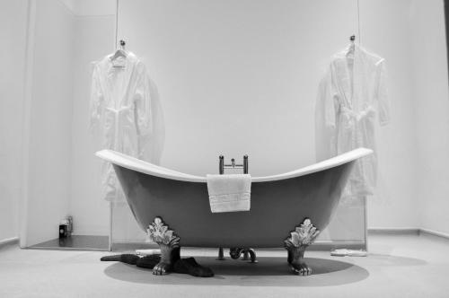 a bath tub in a room with two dresses at Carmelite Hotel in Aberdeen