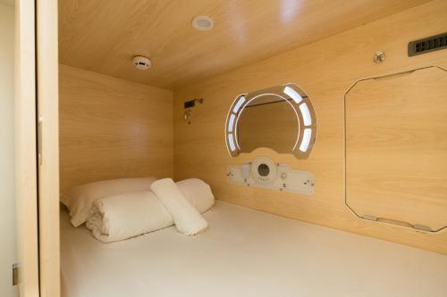 a small room with a bed and a mirror at LumaNest Senawang in Seremban