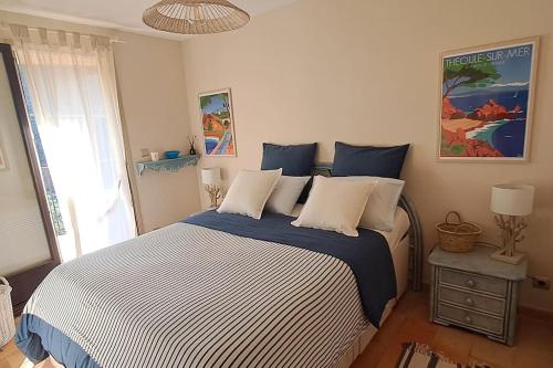 une chambre avec un grand lit avec des draps bleus et blancs dans l'établissement Maison bord de mer - piscine -, à Théoule-sur-Mer