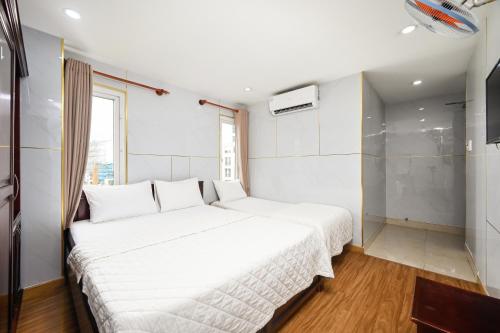 a large white bed in a room with a window at Gia Hoa Airport Hotel in Ho Chi Minh City