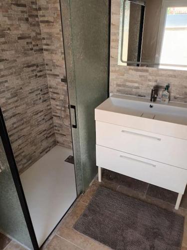 une salle de bain avec un lavabo et une douche avec un miroir dans l'établissement Maison au calme avec piscine, à Alleins