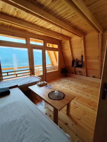 a room with two beds and a table in a wooden room at Sunčani Brijeg Eco Village in Plav