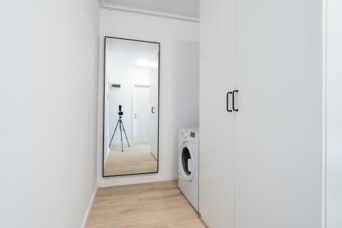 Un espejo en una habitación blanca con una lavadora. en Rares Den 1142, Free parking, Panoramic view, en Bucarest