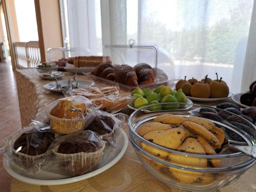 a table with plates of muffins and fruit on it at B&B La Terrazza Degli Scrittori in Racalmuto