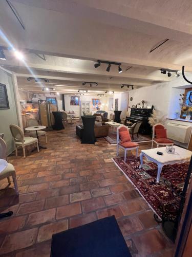 a living room with chairs and tables in a room at Auberge La Plaine in Chabrillan