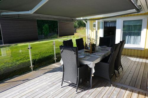 un patio con tavolo e sedie su un ponte di Tranquil Lakeside Cottage Retreat i Garpenberg a Garpenberg