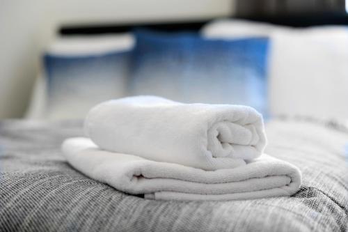 a stack of towels sitting on top of a bed at OrestaLiving - BrigittineurLände in Vienna