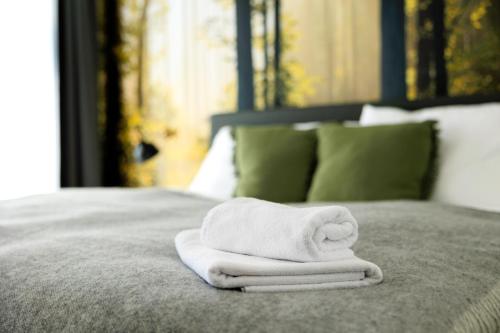 a stack of white towels sitting on a bed at OrestaLiving - BrigittineurLände in Vienna