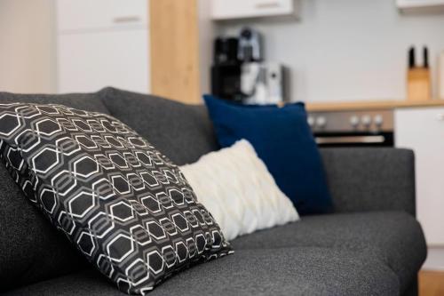 a black and white pillow on a gray couch at OrestaLiving - BrigittineurLände in Vienna