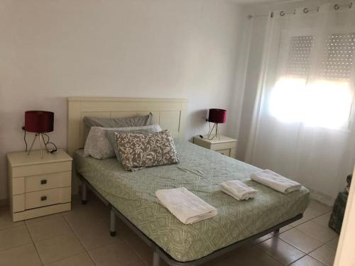 Un dormitorio con una cama con dos toallas encima. en Apartamento Casa Capricho en El Verger Denia, en El Verger