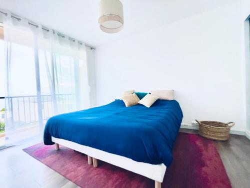 a bedroom with a bed with a blue comforter at Grand Bleu, Vue sur Lac, Cosy et Chic WIFI Centre ville, Plage in Istres