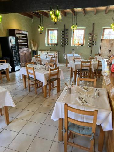 a restaurant with tables and chairs with white tablecloths at Auberge La Plaine in Chabrillan