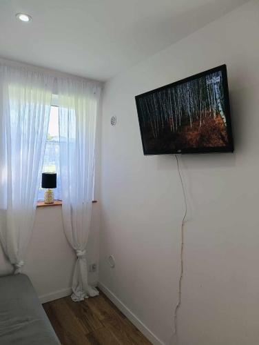 a living room with a television on the wall at Agroturystyka u podnóża Gór Sowich in Pieszyce