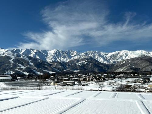 a snow covered city with mountains in the background at Hotel Junior Mint Hakuba in Hakuba