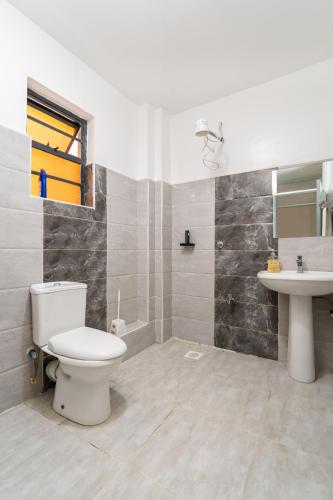 a bathroom with a toilet and a sink at Serene Homes in Ruiru