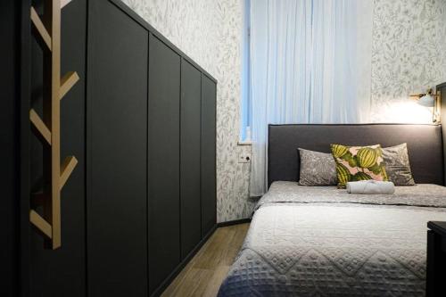 a bedroom with a bed and a large black cabinet at Bright Cozy Apartment in Riga Quiet Center in Riga